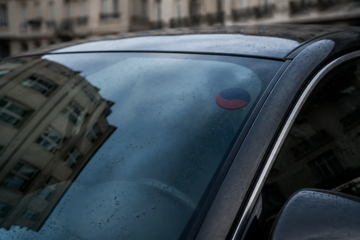Vignette de signalétique apposée sur le pare-brise d&rsquo;une berline sombre